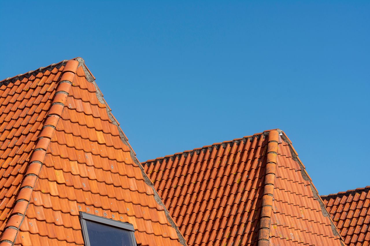 Toiture en tuiles rouges sous ciel bleu